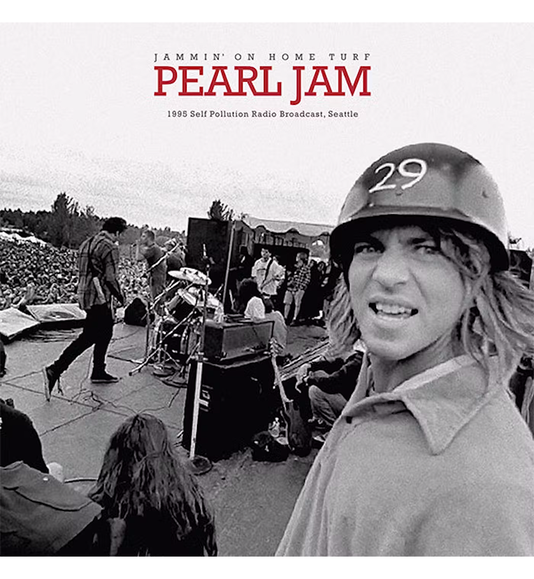 Vinyl record front cover for 'Pearl Jam Jammin’ On Home Turf.' The cover features a black-and-white photo of the band performing live on stage with a large crowd in the background. Eddie Vedder, wearing a helmet with the number 29, is prominently featured in the foreground. The title 'Pearl Jam' is displayed in red letters at the top, with 'Jammin’ On Home Turf' and '1995 Self Pollution Radio Broadcast, Seattle' written below it.