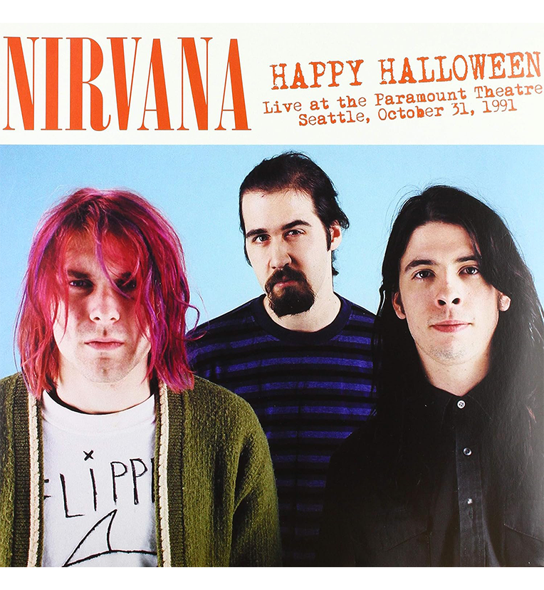 Vinyl record front cover for 'Nirvana Happy Halloween.' The cover features a photo of the three band members, Kurt Cobain, Krist Novoselic, and Dave Grohl, against a light blue background. The title text 'Nirvana' and 'Happy Halloween' is prominently displayed at the top, along with 'Live at the Paramount Theatre, Seattle, October 31, 1991.'