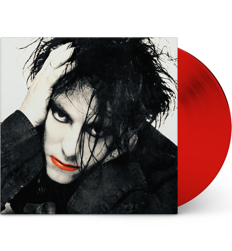 A mockup image of a vinyl record ‘The Cure – Live in Washington, D.C., 1984’. The cover displays a high-contrast black and white portrait of Robert Smith with wild, dark hair and heavy eyeliner. His face partially covered by his hand, which rests on his head. His lips are painted bright red, adding a splash of color to the monochromatic image. The vinyl record is bright red, partially visible on the right side of the image.